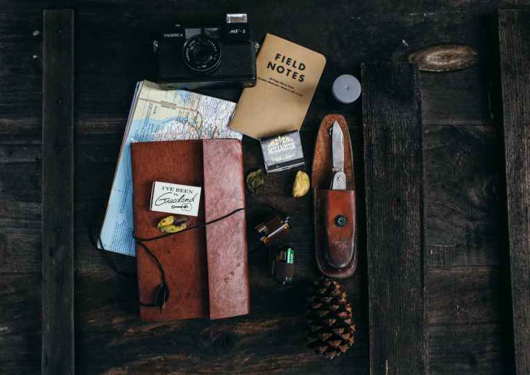 retro camera near notepad and knife near map on desk